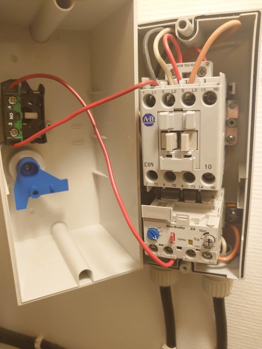 Elektrisk kopplingslåda med kablar och säkringskomponenter i en vägg, problem med surrande ljud beskrivs.