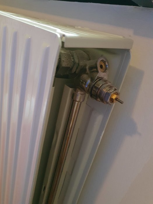 Radiator med en demonterad termostatventil som illustrerar frågeställarens problem.