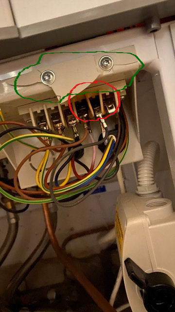 Elcentral med tydliga tecken på bränning vid röd ring och skadad plast vid grön markering.