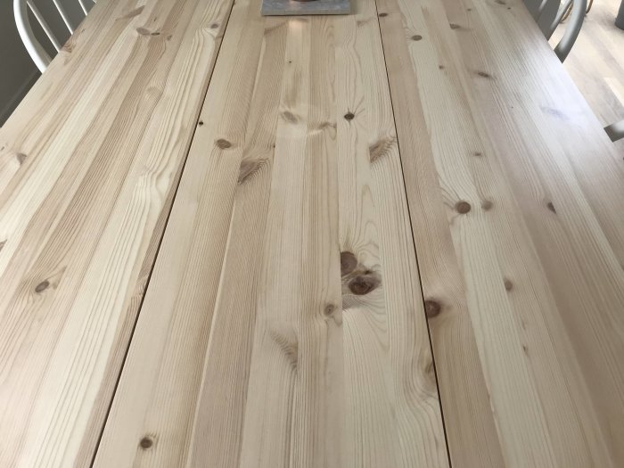 Närbild på ett ljust träbord med limfog skivor och synliga ljusa fläckar på ytan.