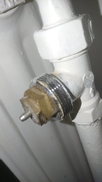 Termostatventil på radiator utan termostat, bundet med buntband för att reglera värme.