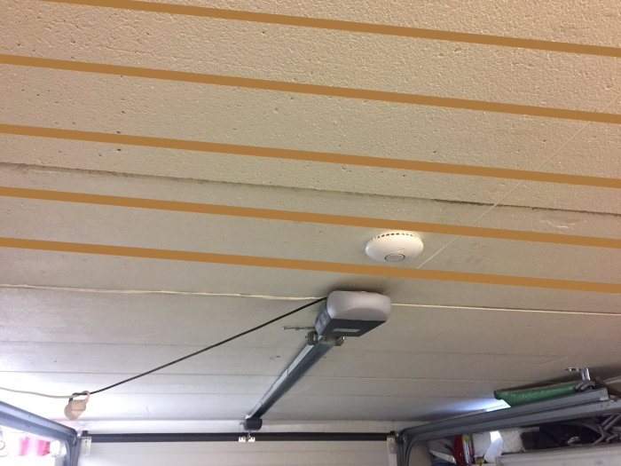 Loft med orange linjer viser armeringens mulige placering i betonplader. Røgdetektor og garageportåbner ses på loftet.