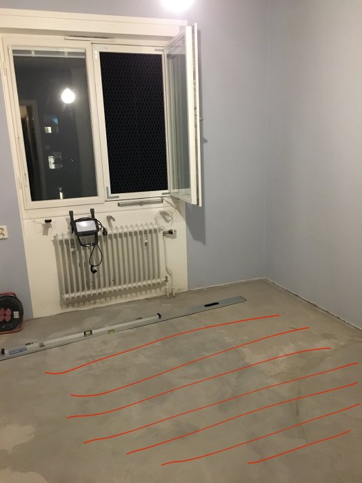 Renoverat rum med ny golvvärmeinstallation, fönster öppet och radiator till vänster.