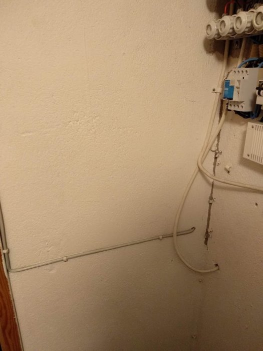 Elledningar och skyddsledare installerade på en vägg som går till infällda armaturer, strömbrytare och vägguttag.