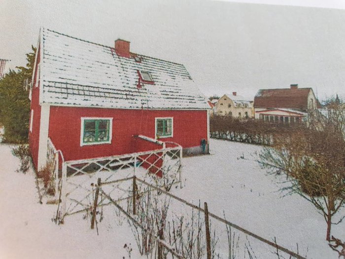 Renoverat rött hus med nytt tak i vinterscen med snö.