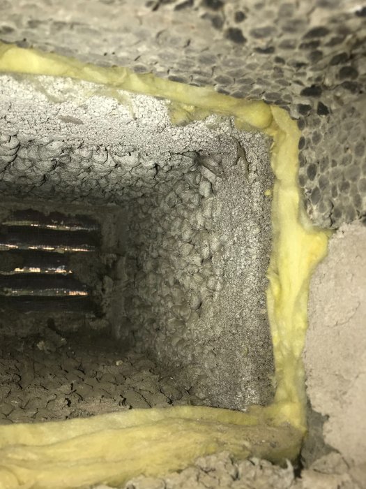 Inspektionshål visar isolering direkt mot betong, inget mellanrum som skulle fungera som luftspalt.