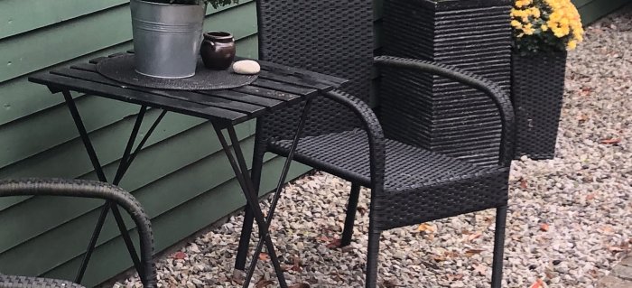 Utemöbler vid en grön vägg med en "grusram" på marken, fråga om att åtgärda liknande delar vid garage.