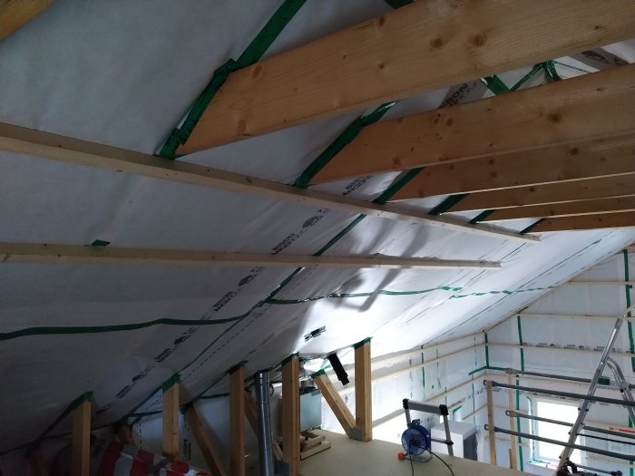 Nyinstallerade träreglar i taket med c/c-avstånd på 450 mm i ett pågående byggprojekt.