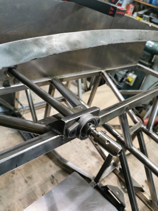 Metallkonstruktion med påpunktat snap-off fäste på axel som inte är i mitten.