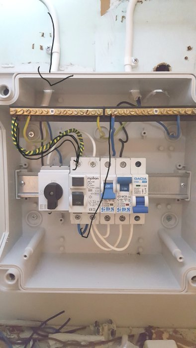 Elektrisk fördelningslåda med fel färgkodad PEN-ledare markerad av pil enligt inlägget.