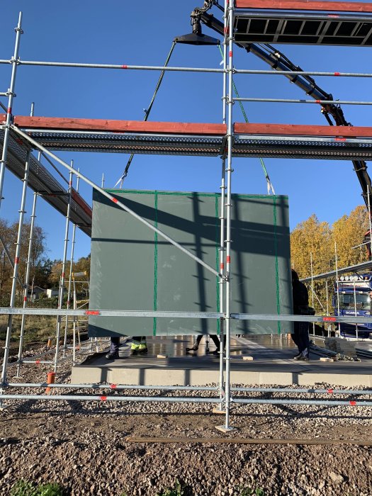 Monterad stomme i block med utegips på byggarbetsplats under en solig dag.