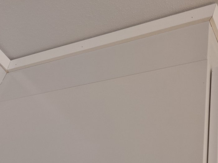Täcksida på köksskåp som inte når upp till taket, gap synligt.