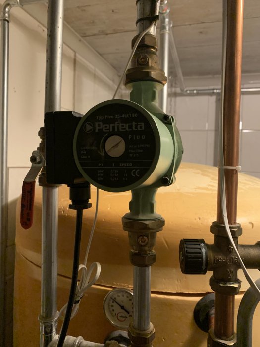 Varmvattenpumpsinställningar och mätare på en ackumulatortank i ett värmesystem.