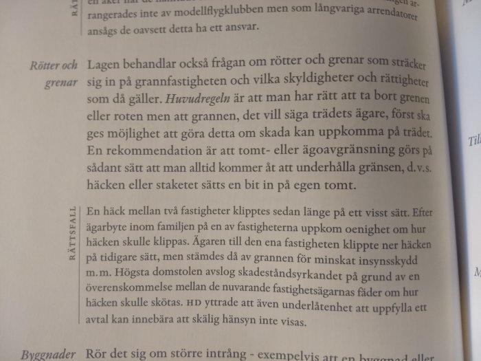 Öppen lärobok med text om fastighetsrätt, fokuserad på avsnitt om rötter och gränsfrågor.