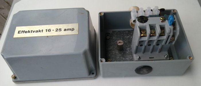 Öppen grå låda med etikett "Effektvakt 16 - 25 amp" och inre elektriska komponenter inklusive motorskydd.