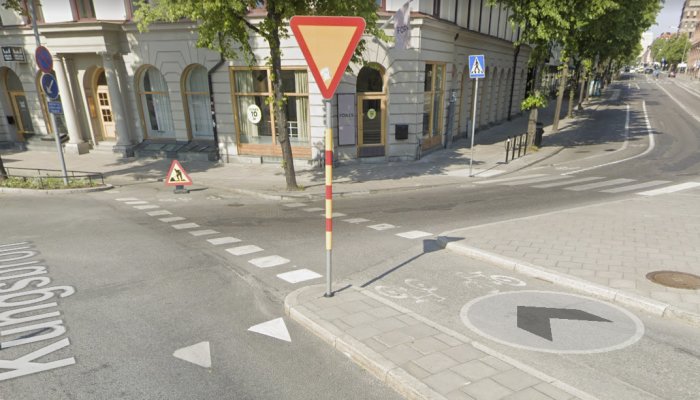 Cykelbana på Kungsbron i Stockholm med vägmarkeringar, väjningspliktsskylt och pil för högersväng.