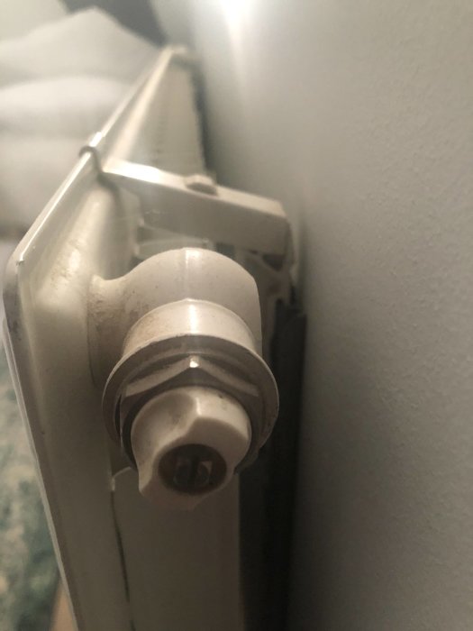 Närbild av en tveksam luftventil på ett element med en otydlig nyckelöppning.