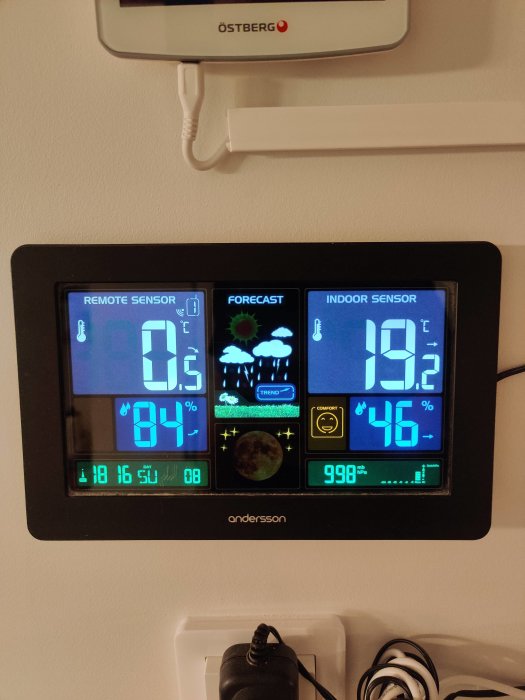 Digital väderstation som visar 0.5 °C ute, 19.2 °C inne och väderprognos av snöflingor.