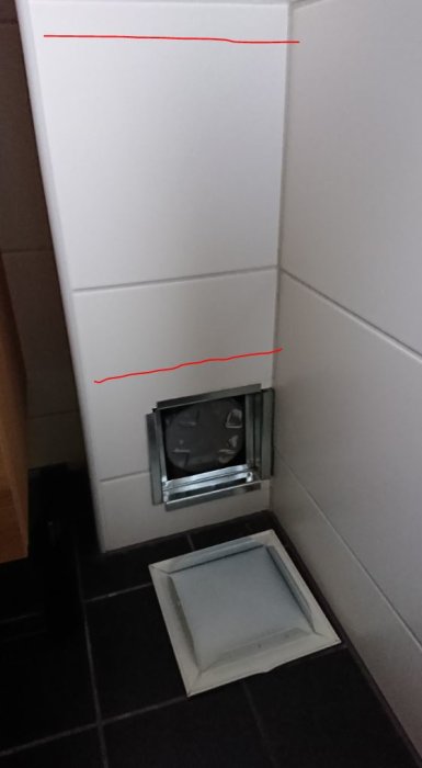 Nyinstallerad renslucka i kaklat badrumsgolv med tillhörande vägg där PEX-rörskarvar finns.