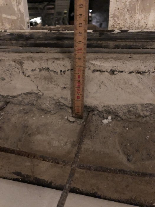 Mätning av höjdskillnad vid en grundmur för ett uterum med en skjutmåttstav vid en skjutdörr.