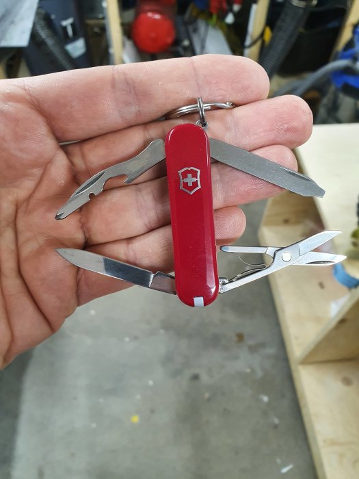 Ny Victorinox Rambler multiverktyg på en nyckelring som hålls i en hand, öppnad med verktyg synliga.