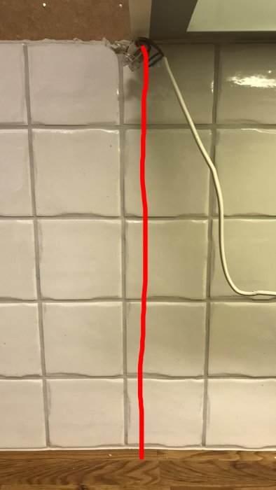 Köksvägg med kakel och röd markeringslinje där kaklet ska kapas för renovering.