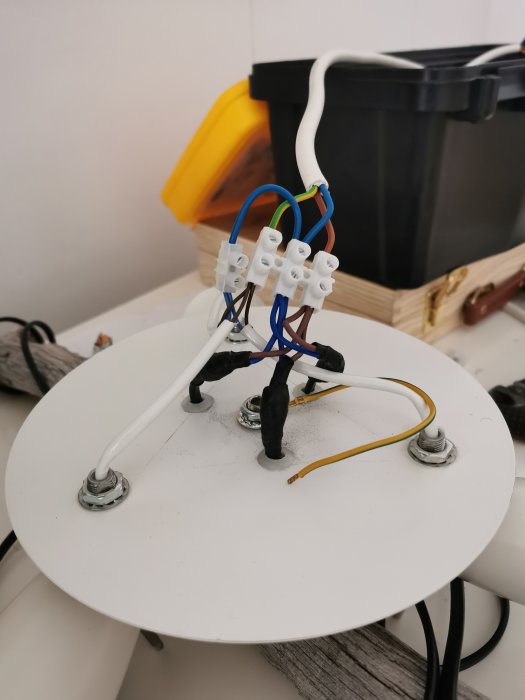 Elektrisk anslutning med flera ihopkopplade kablar och kontakter på en vit plattform.