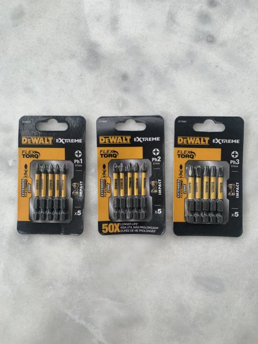 Tre förpackningar med DeWalt Extreme FlexTorq skruvbits upplagda på snö, märkta PH1, PH2 och PH3.