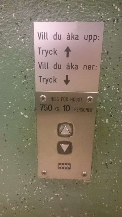 Hissknappar med instruktionsskylt som visar vart man ska trycka för att åka upp eller ner.