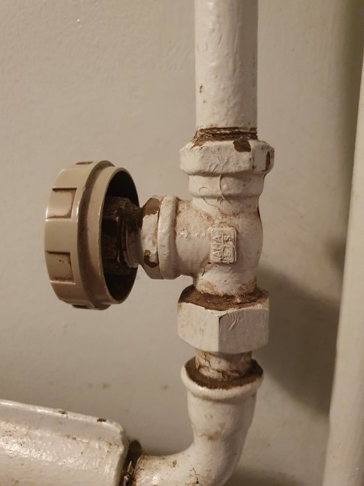 Gammalt radiatorvred märkt "AHA" som är fast eller sönder, på ett element från 1950-talet.