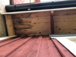 Plåttak möter trävägg med synlig fukt och uppvikt duk, potentiell vatteninträngningspunkt.