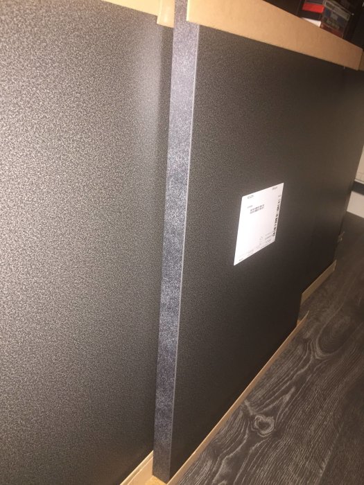 Färgskillnad mellan ovansidan och kanten på EKBACKEN svart stenmönstrad laminatbänkskiva.