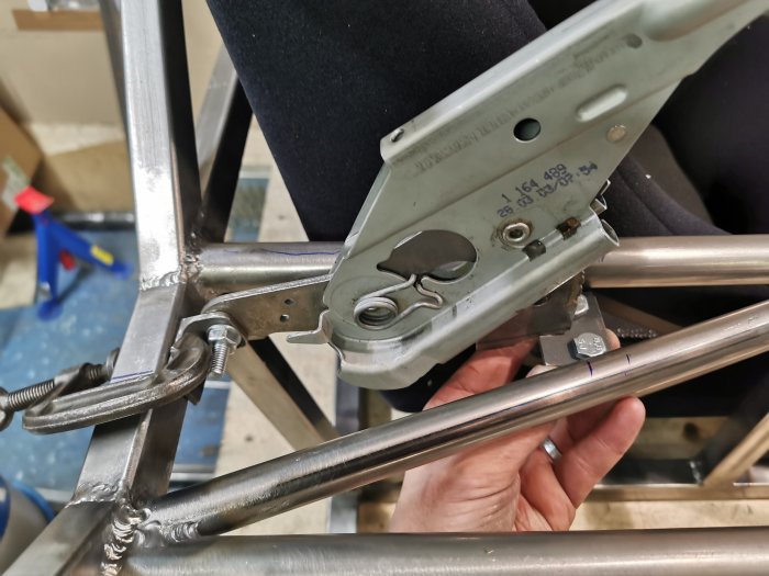 Närbild av en hand som använder en häftpistol för att fästa i en metallkonstruktion.