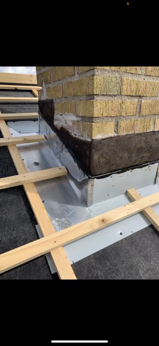 Vägg och tak i skarv med tätskikt och träreglar vid byggprojekt.