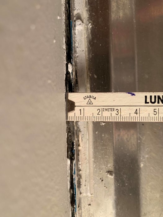 Måttband visar 5mm glipa mellan vägg och kant av diskbänk från 60-talet inför kakelprojekt.