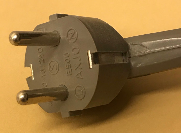 Närbild av ett grått elkabel med stickkontakt som har ett utstickande skyddsjordstift överst.
