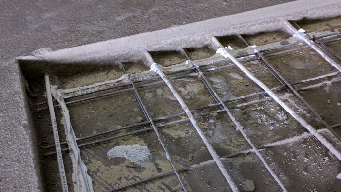 Golvvärmerör på armeringsnät ovanpå möjlig betonggrund före flytspackling.
