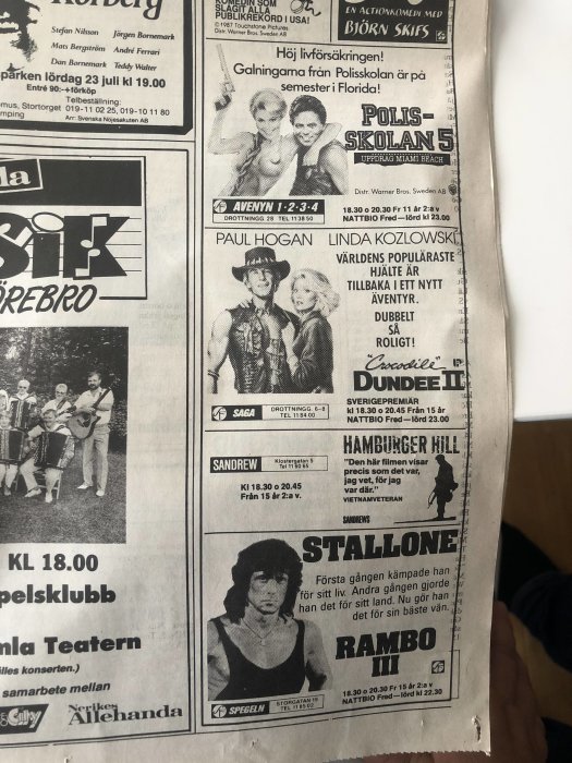 Gammaldags tidningssida med filmannonser för "Polisskolan 5", "Crocodile Dundee II" och "Rambo III".