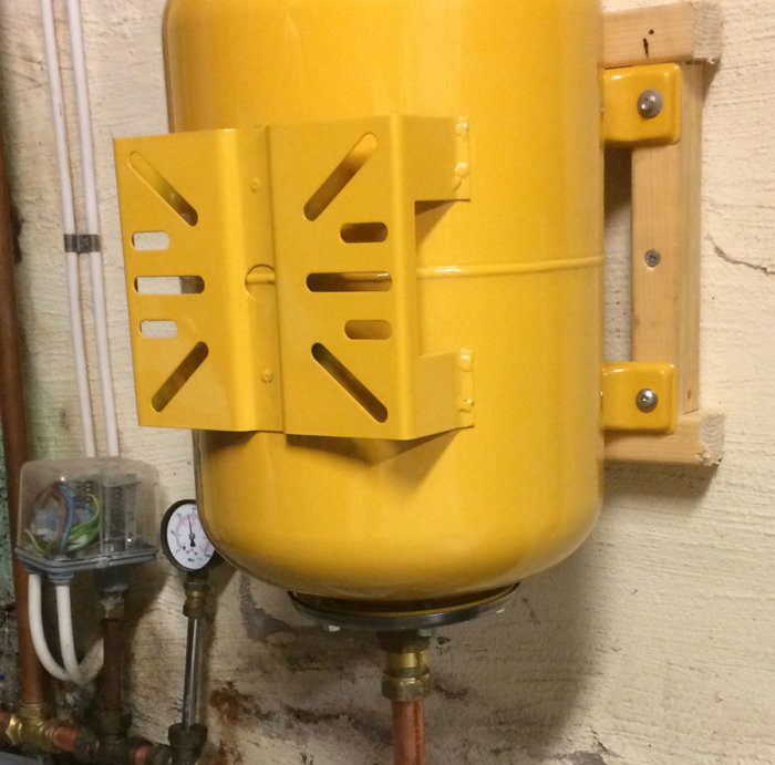 Hydrofortank monterad på vägg med synliga rör och tryckmätare samt en liten läcka.