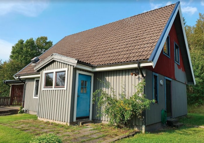 Ett hus med nybyggd takkupa och flyttad trappa, med fasad som väntar på renovering och en veranda som ska få spröjs och en balkong ovanpå.