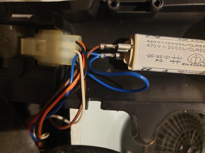 Kondensator kopplad till motor med sju elektriska trådar i olika färger, misstänks vara felaktig.