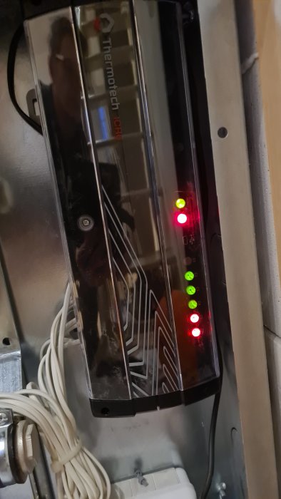 Basenhet för värmesystem med två röda och flera gröna lysande indikatorlampor.