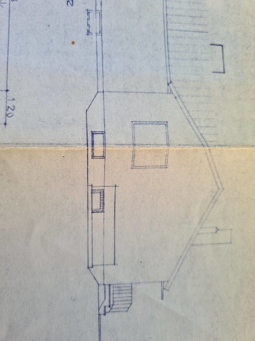 Delvis vy av en arkitektonisk ritning med linjer som visar konturerna av en byggnadsplan.