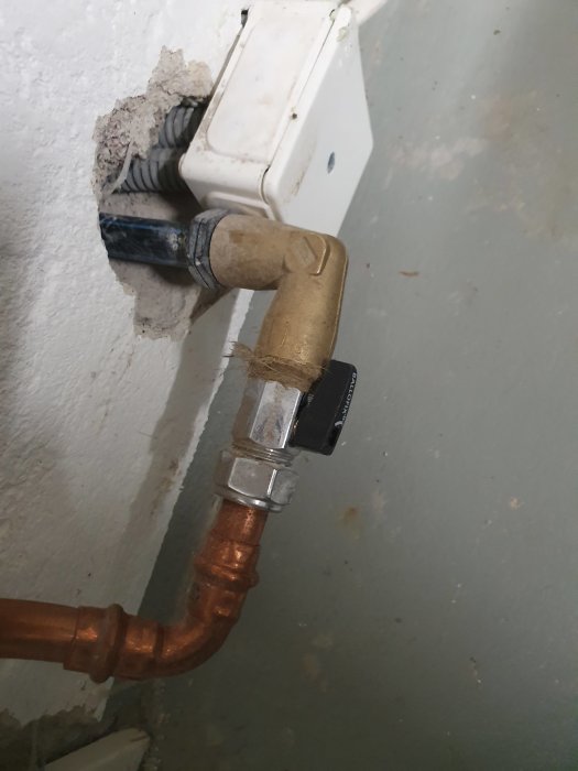 Kopparrör med 90-gradersvinkel och ballofix genom vägg för vattenanslutning.