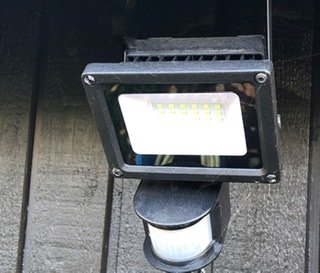 LED-säkerhetslampa med rörelsesensor installerad på en yttervägg.