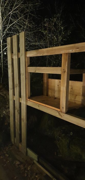 Påbyggnad av ett plank med 22x120 lockpanel och en oavslutad dold förvaringslucka i träkonstruktionen.