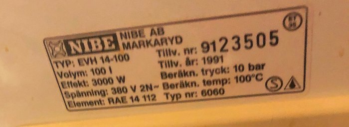 Etikett på varmvattenberedare med tekniska specifikationer, modell och serienummer.