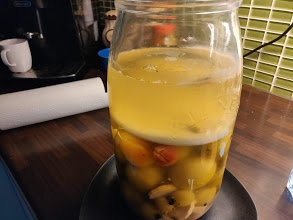 Glasburk med gröna tomater och synligt mögel på ytan, använd för surkål och liknande.