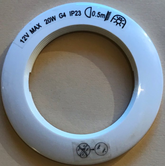 Spotlight ram med märkning 12V MAX 20W G4 IP23 på vit bakgrund.