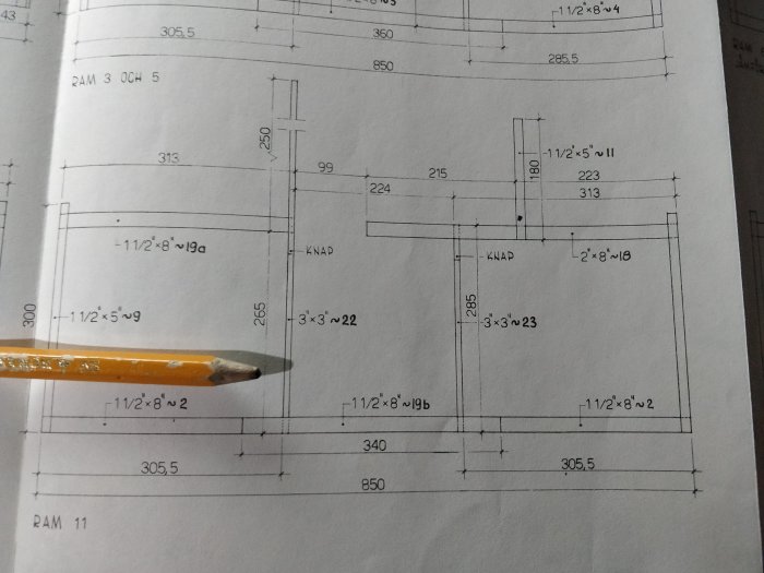 Floor plan with dimensions and a pencil pointing at the diagram, related to structural elements of a building project.